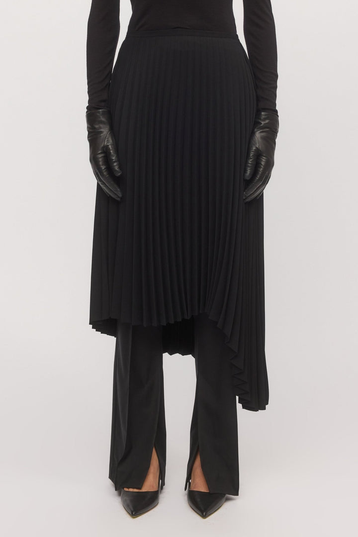Close-up of the black Asymmetric Pleat Skirt showcasing sunray pleats and fine fabric texture, highlighting movement and craftsmanship.