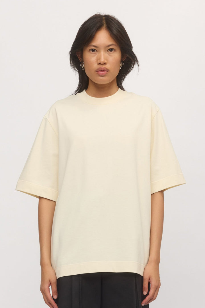 Close-up of the Boyfriend Tee in Natural, showing the soft cotton texture, ribbed crew neckline, and wide hem on a relaxed oversized fit.