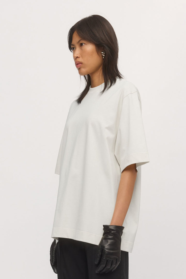 Side profile close-up of woman in oversized Boyfriend Tee White – casual drape and soft jersey fabric highlighted.