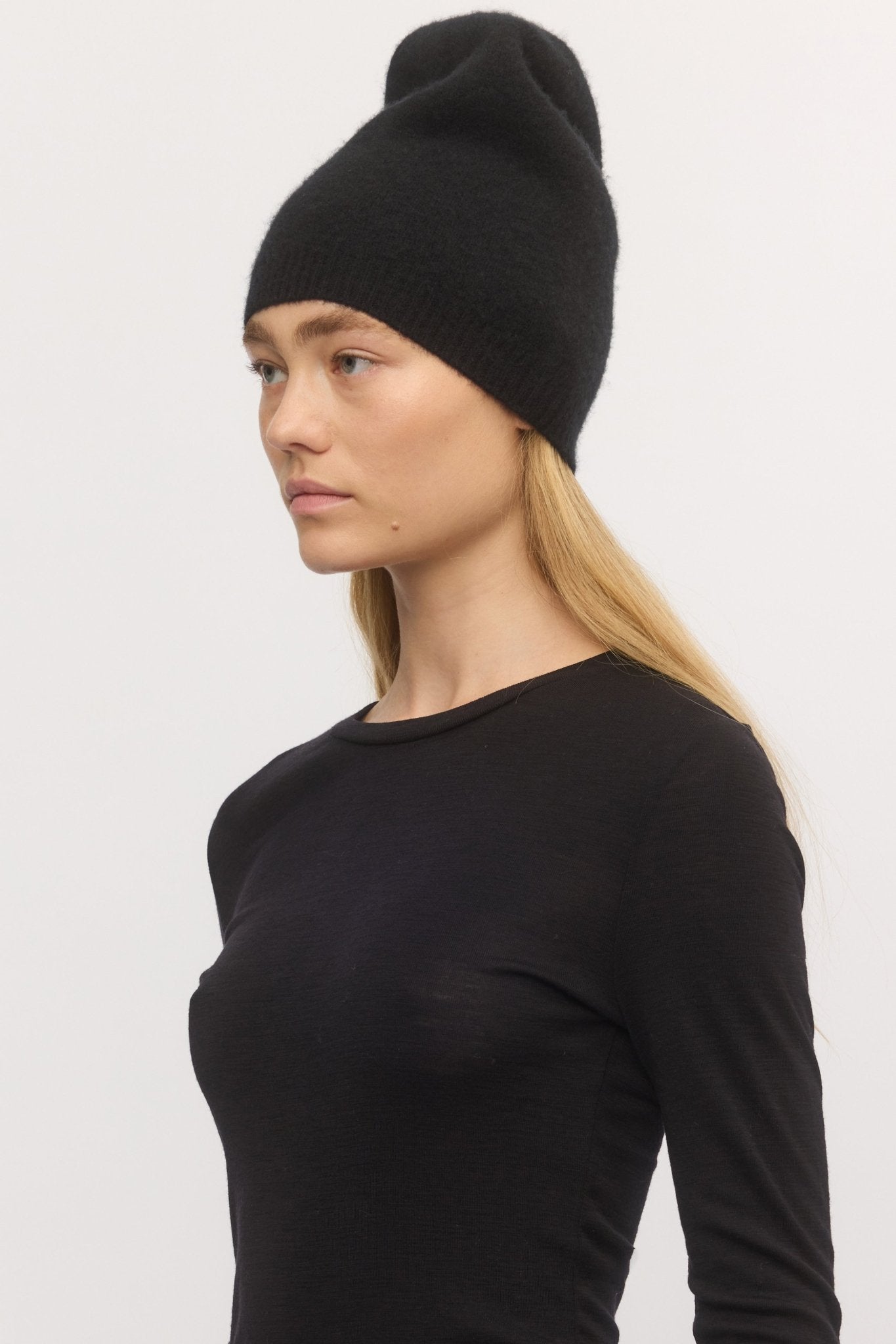 Side view of woman in Brushed Effect Beanie Midnight โ deep navy wool-cashmere beanie with plush brushed texture, styled with a black top.