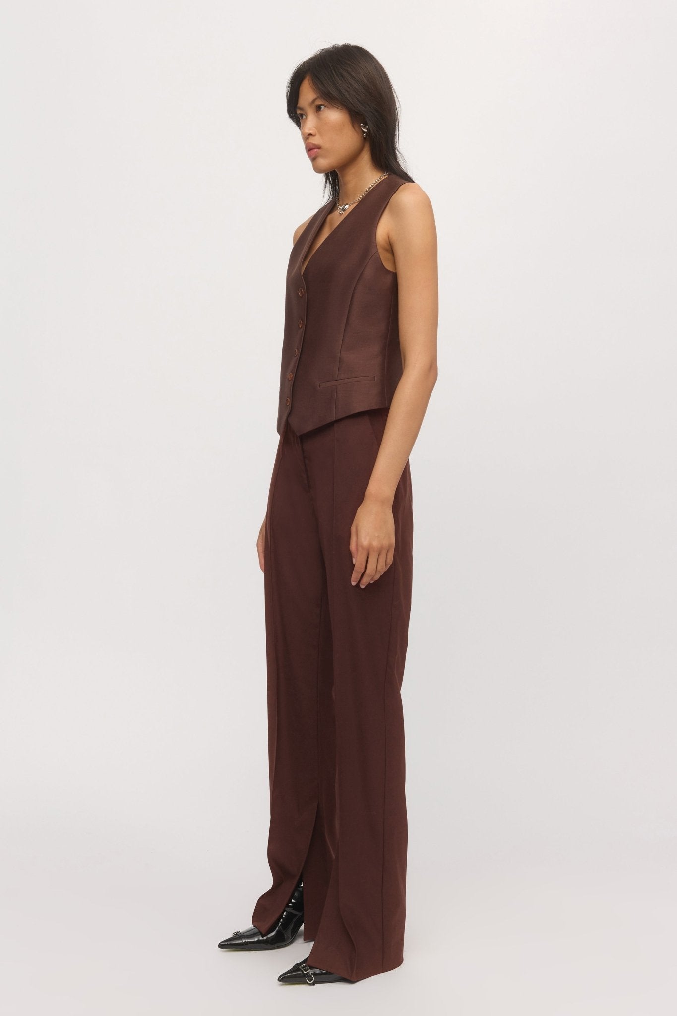Side view of woman in Button Down Vest – clean tailoring and structured fit shown in profile.