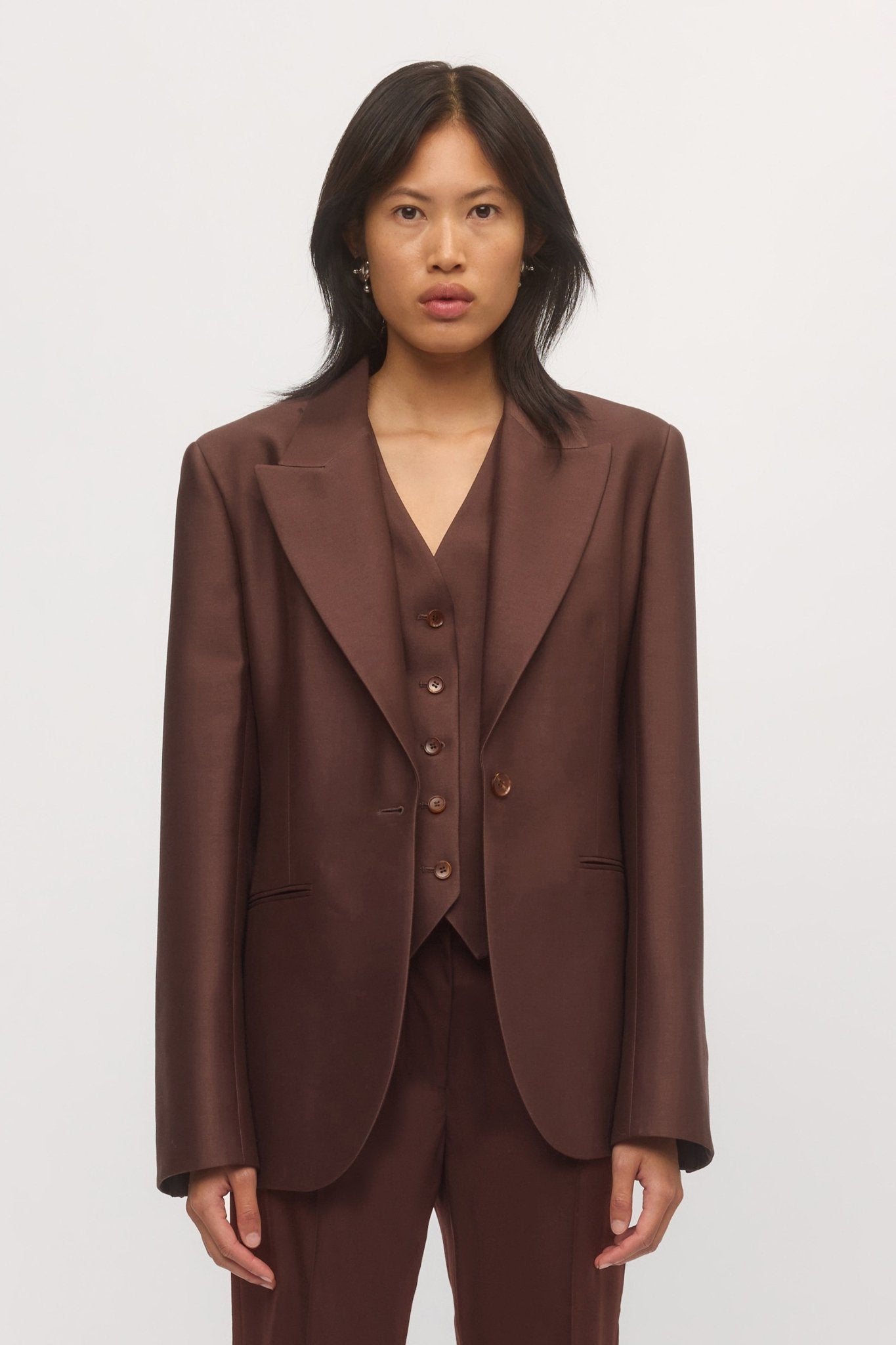 Woman wearing Button Down Vest under matching Single Button Blazer – modern tailored ensemble in tonal brown.