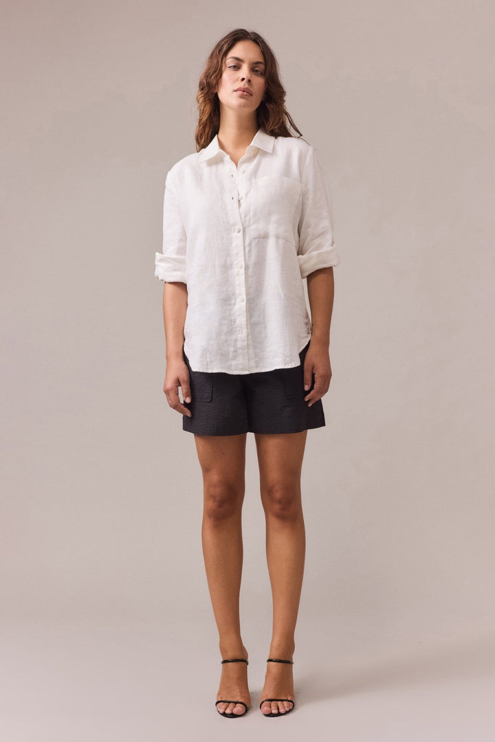 A woman is wearing Crawford textured cotton short paired with white shirt with sleeves rolled-up.