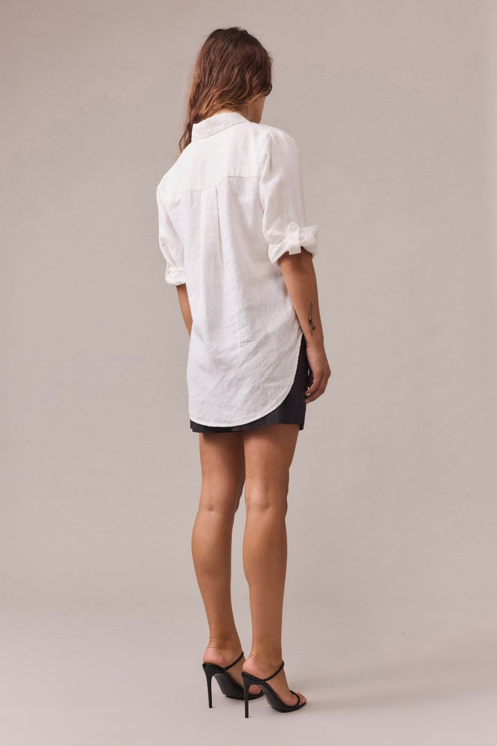 A back view of women wearing white shirt with black cotton shorts.