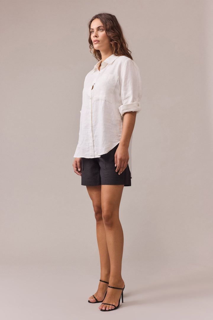 A side view of a woman is wearing Crawford textured cotton short paired with white shirt with sleeves rolled-up.