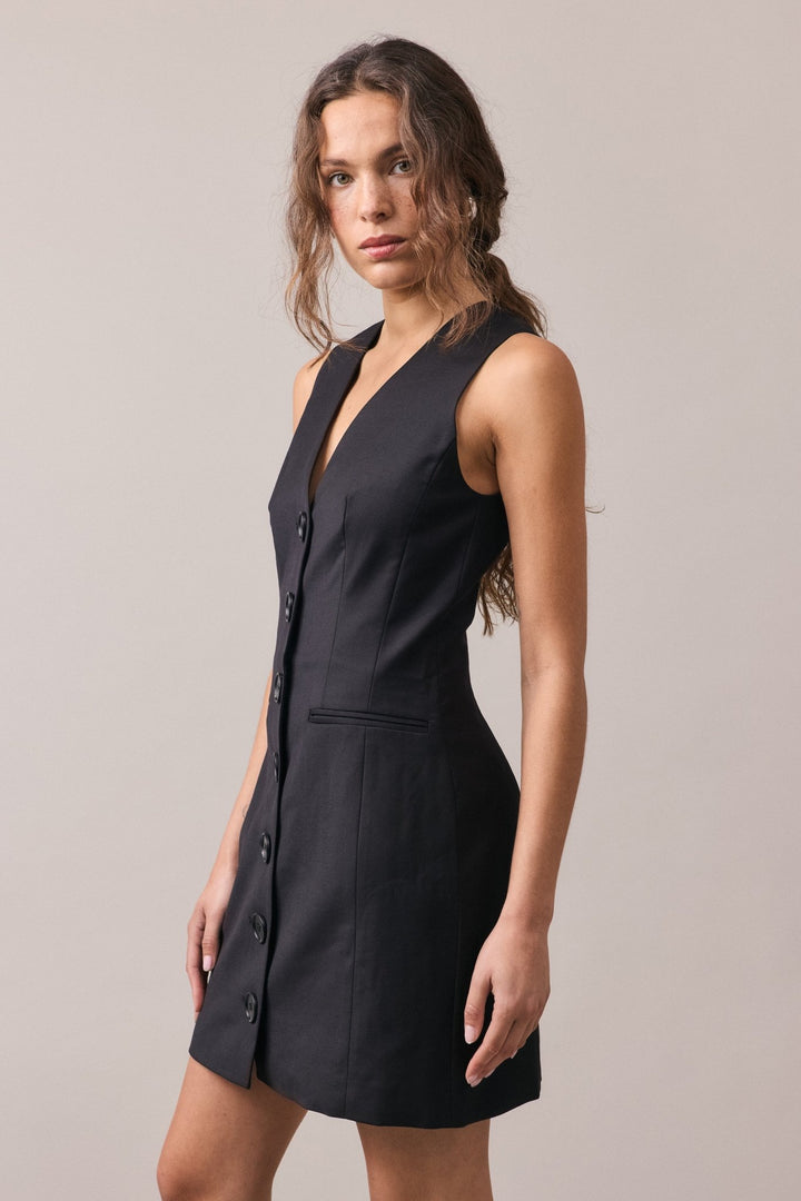 The Havana Tailored Dress in black, showcasing its expertly tailored fit, subtle A-line silhouette, and lightweight wool fabric. The structured design and functional button detail add a sleek, modern touch.