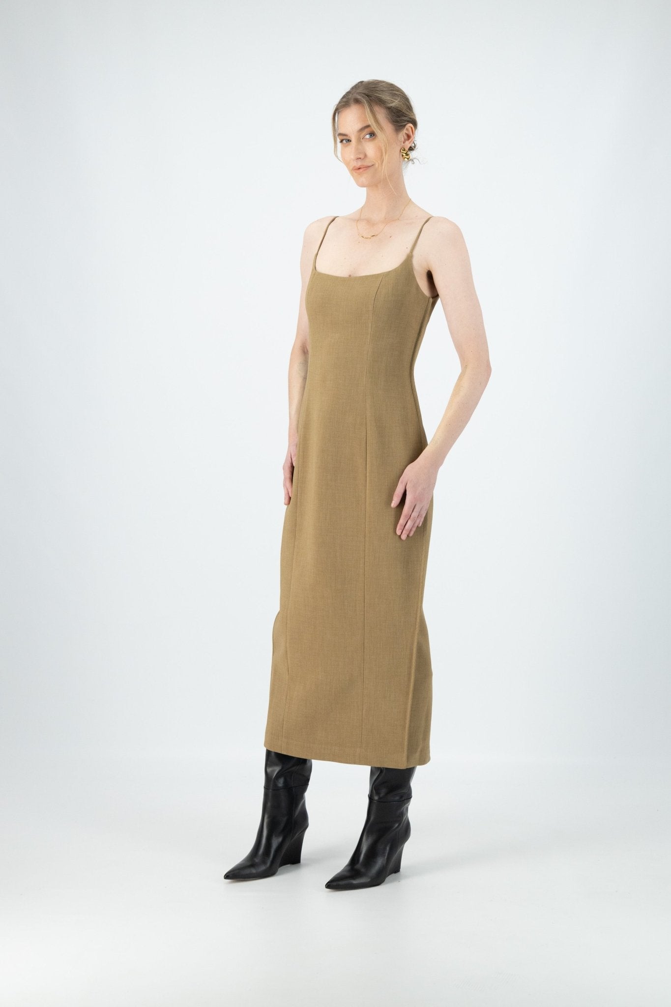 A woman is wearing a brown midi dress with thin straps.
