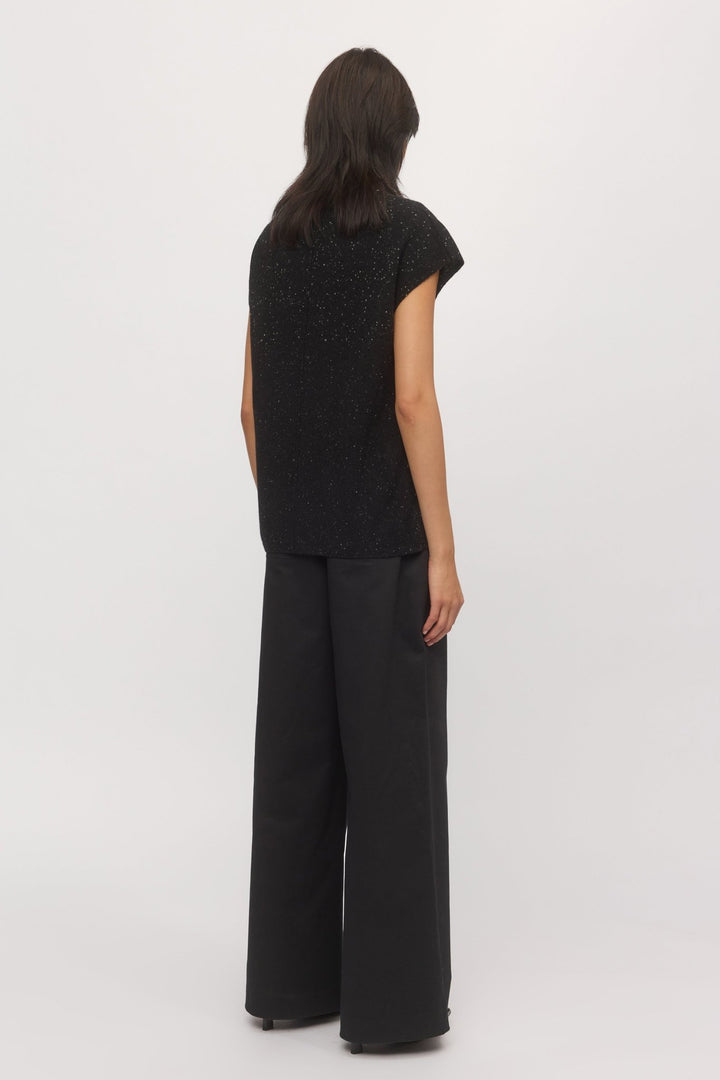 Back view of a woman wearing a knit tank top with wide-leg pants.