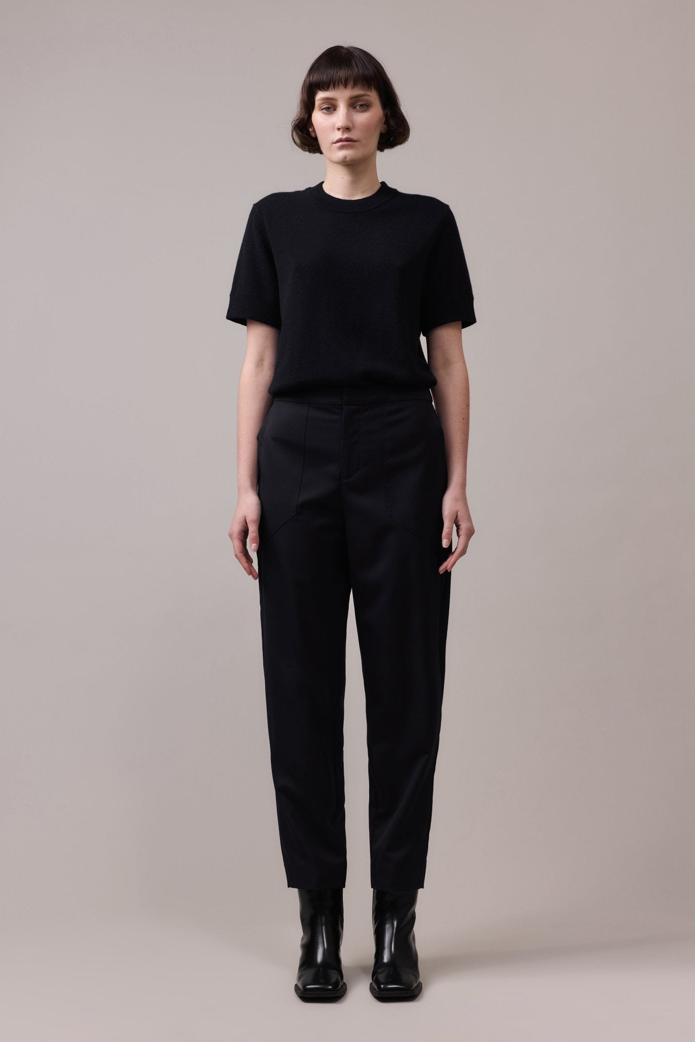 Full view of the woman in the black Marlow Casual Pant paired with a black t-shirt, creating a minimalist, polished outfit that offers both style and comfort.