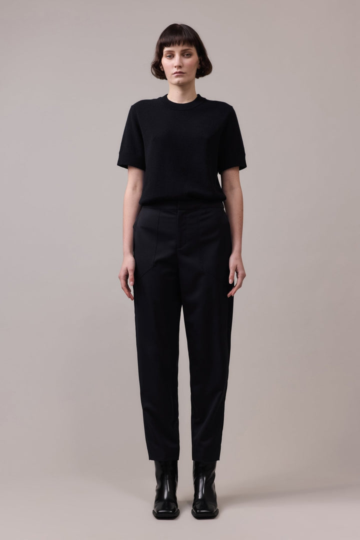 Full view of the woman in the black Marlow Casual Pant paired with a black t-shirt, creating a minimalist, polished outfit that offers both style and comfort.