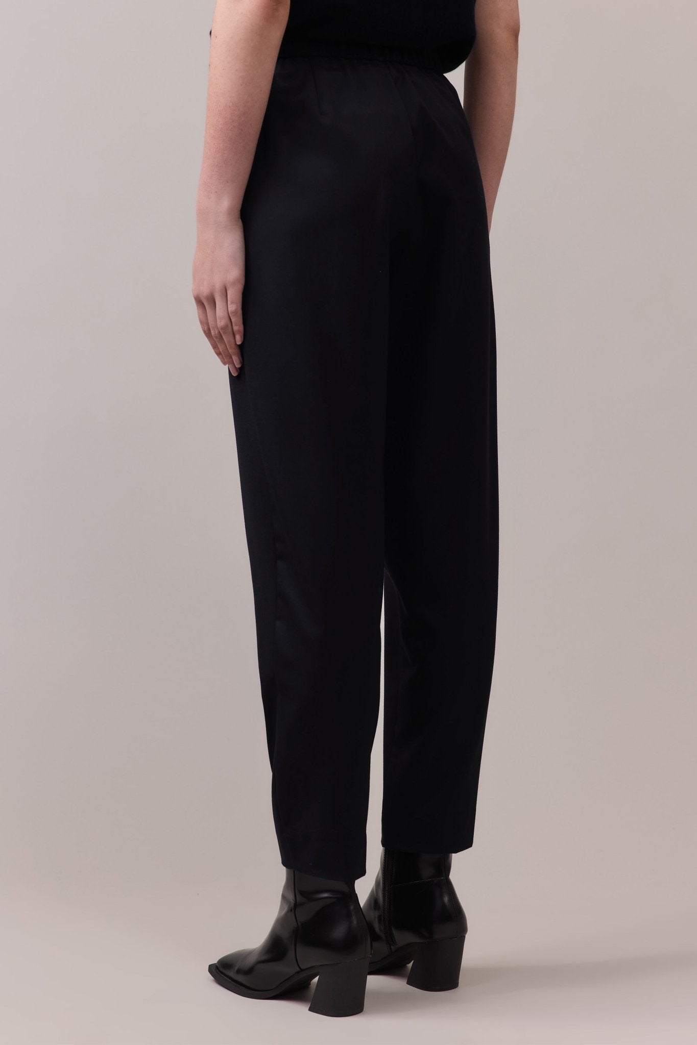 Back view of the black Marlow Casual Pant, showcasing the comfortable elastic waistband and the fluid movement of the wool fabric.