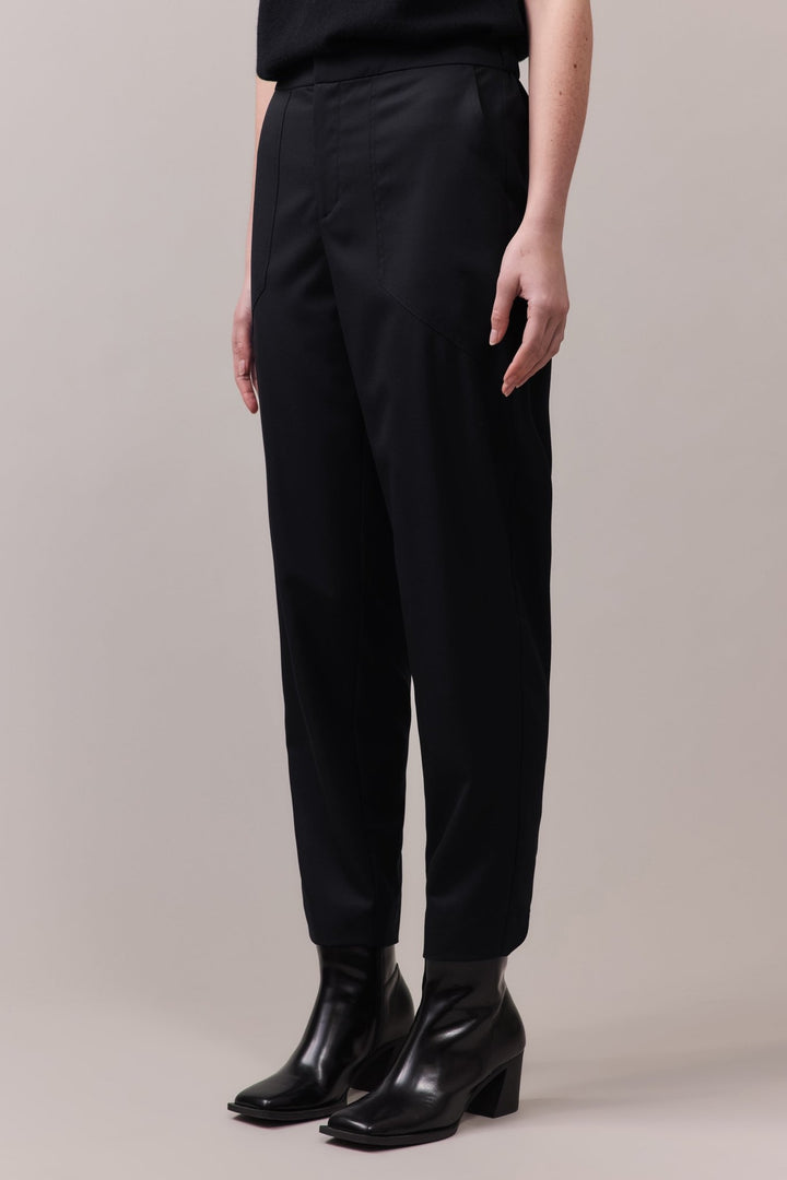 Side view highlighting the relaxed fit and front pockets, crafted from 100% wool for a stylish and sophisticated look.