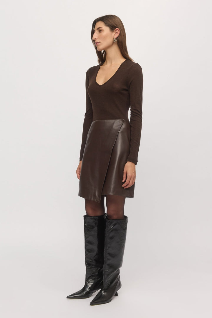 Side view of mahogany Merino V-neck sweater styled with brown leather skirt – Skin and Threads