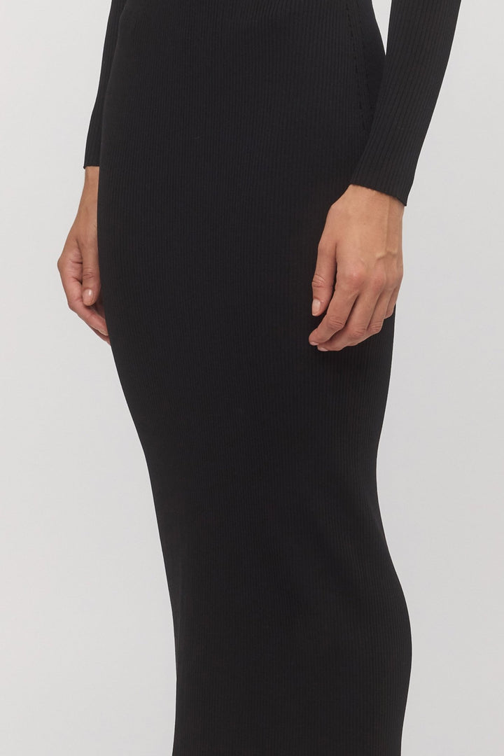 Close-up detail of ribbed texture and curved sleeve seam on black knit dress โ Skin and Threads