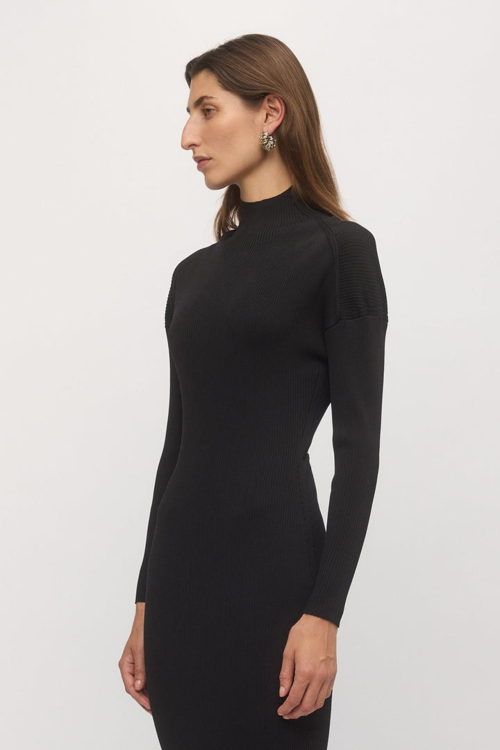 Side profile of woman wearing black Open Back Rib Dress showing fit through waist and sleeves โ Skin and Threads