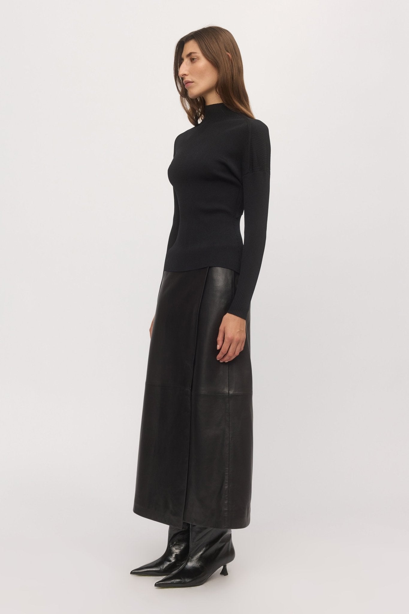 Side profile view of Open Back Rib Top styled with black leather maxi skirt and pointed boots – Skin and Threads