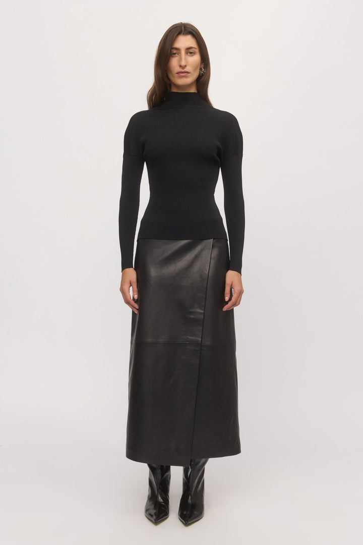 Front view of woman wearing Open Back Rib Top in black rib knit with high neckline and slim fit, styled with black leather skirt – Skin and Threads