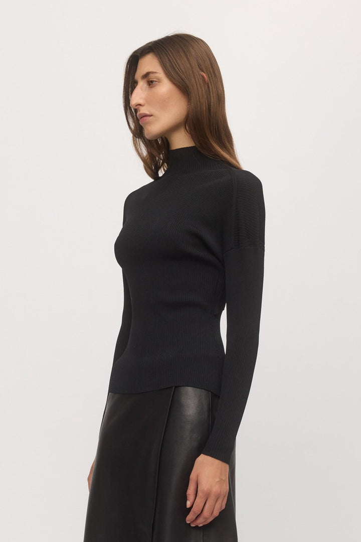 Side profile of Open Back Rib Top styled with leather skirt, highlighting fitted rib silhouette and high neckline – Skin and Threads