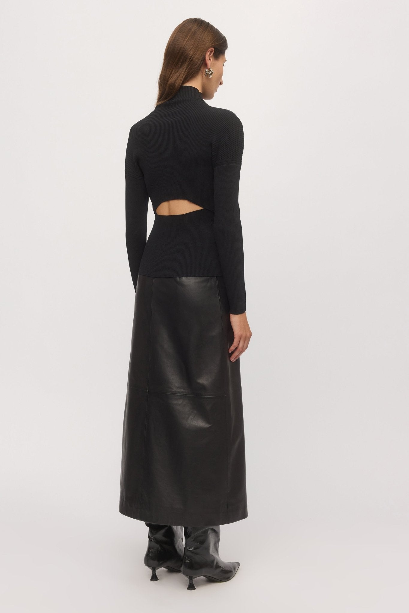 Back angled view of Open Back Rib Top showing waist cut-out and long sleeves styled with black skirt – Skin and Threads