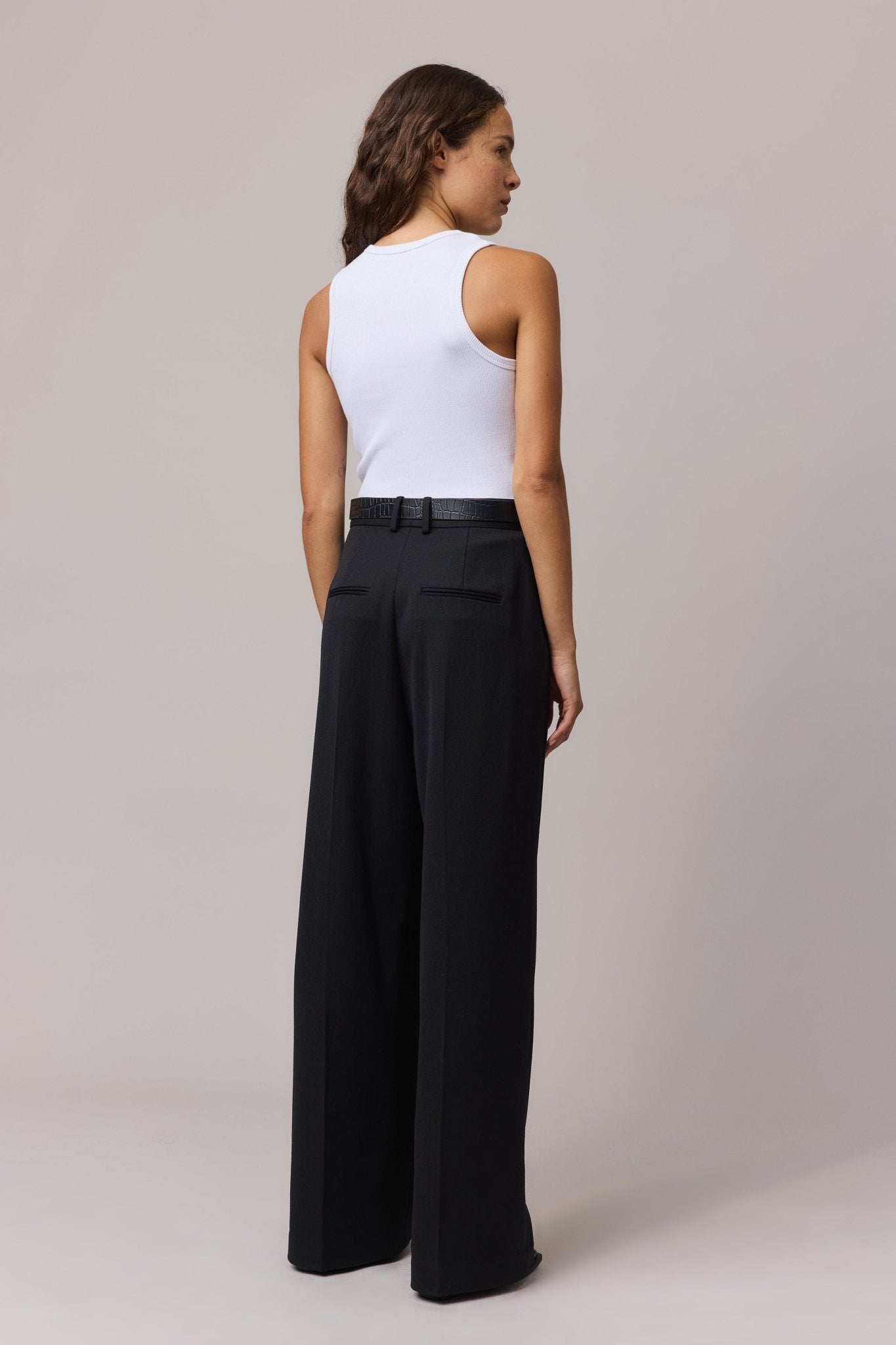 Back view of a woman wearing the white cotton rib tank top, highlighting the stretch fabric.
