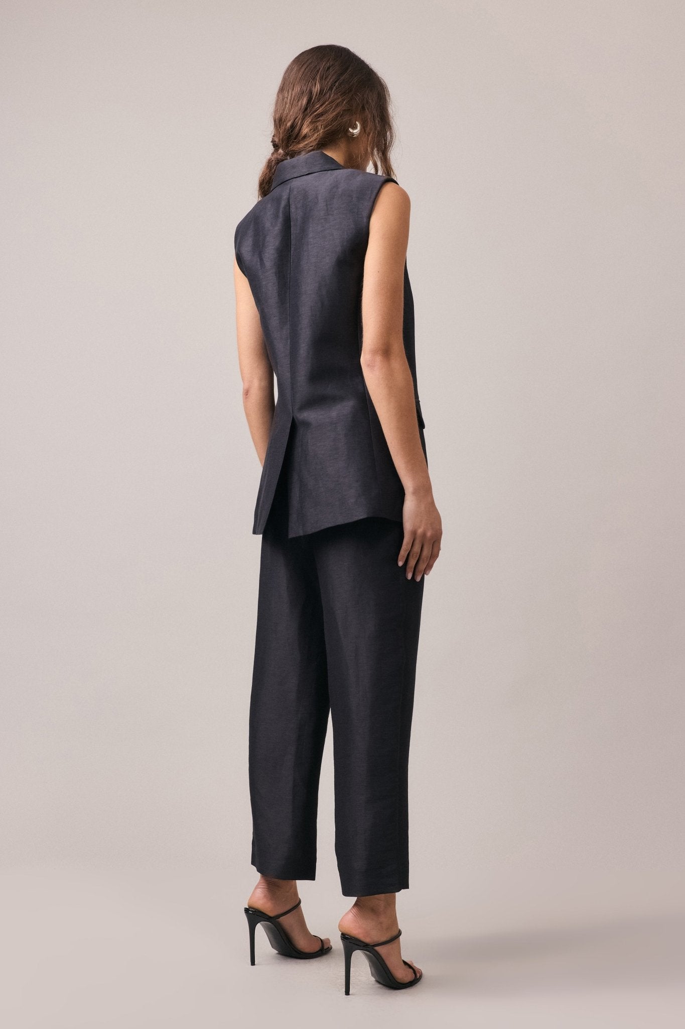 Woman wearing the Remi Silk Linen Pant with the matching longline vest, viewed from behind.