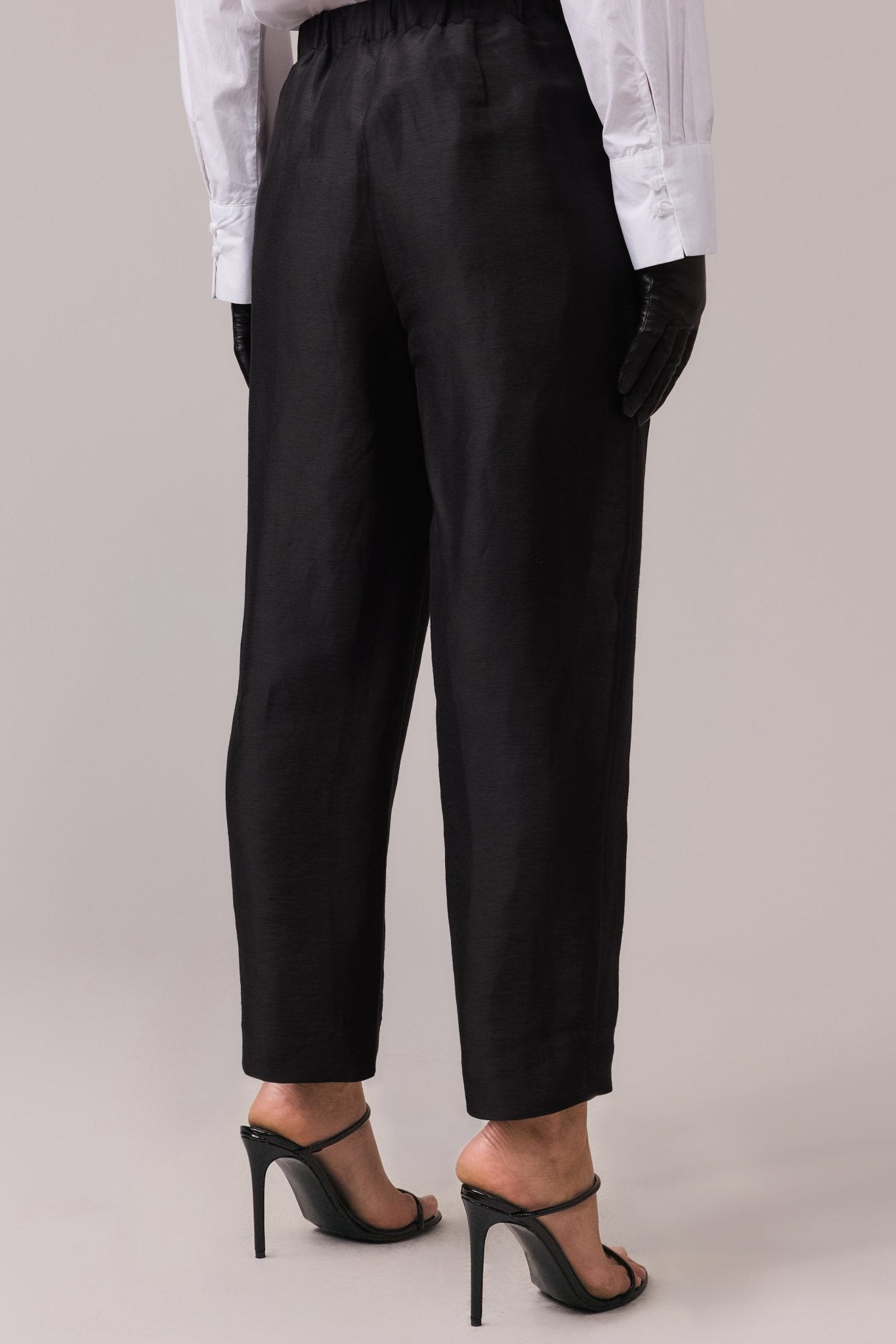 Woman wearing the Remi Silk Linen Pant from behind, showcasing the relaxed fit and tailored waistband with the elastic back for added comfort.
