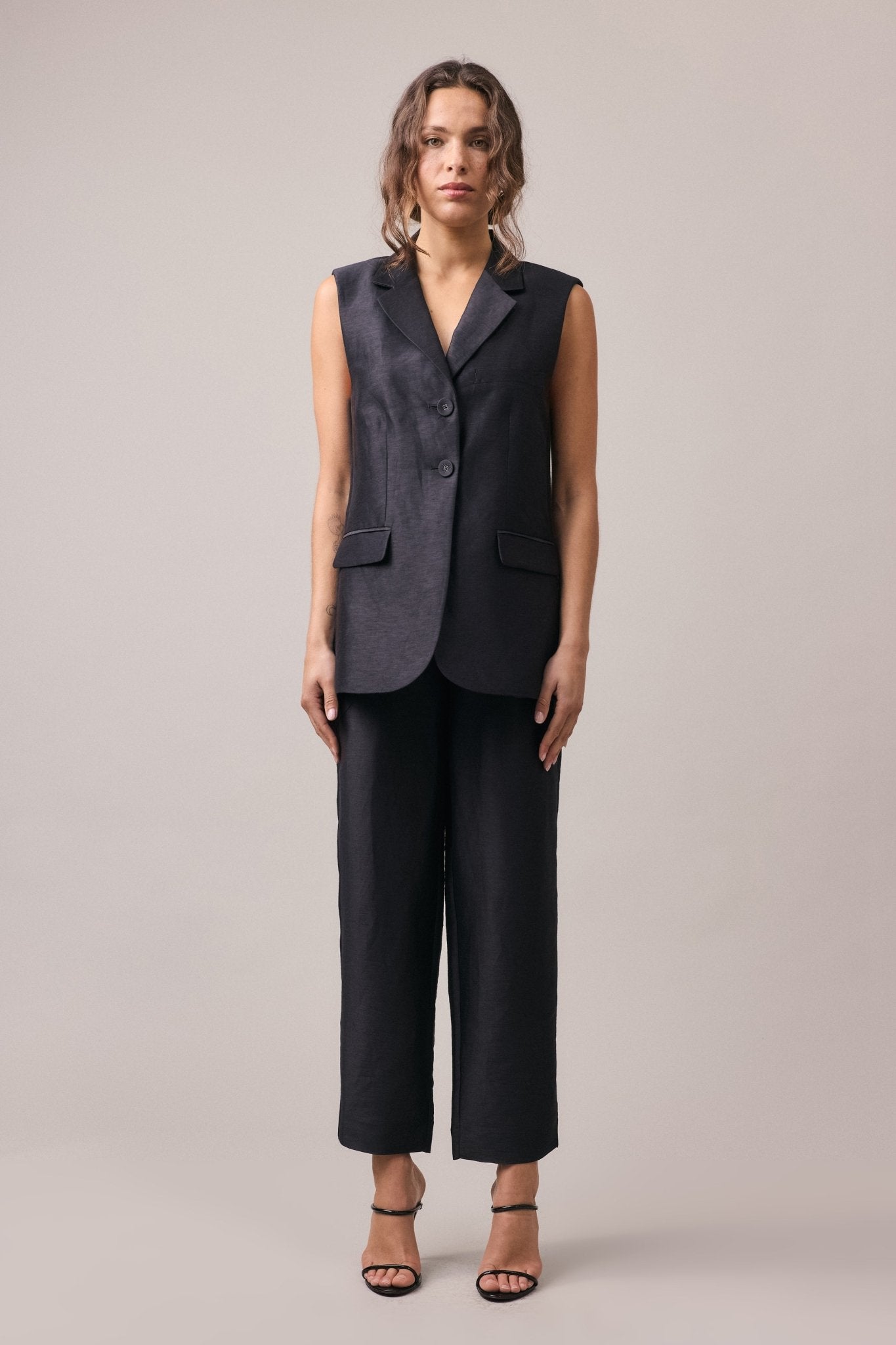 Woman wearing the Remi Silk Linen Pant paired with the matching longline vest. The relaxed, slimline fit of the pants complements the sophisticated, yet comfortable look