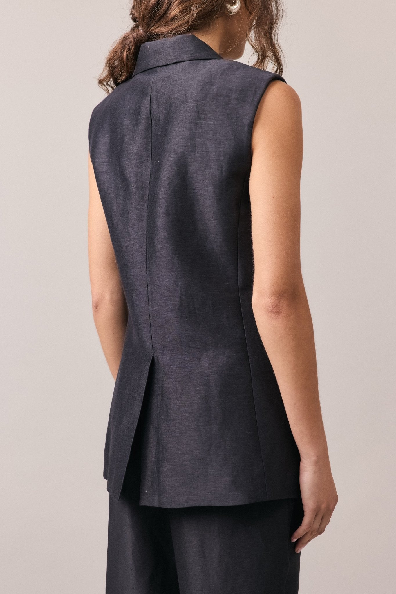 Close-up view of the Remi Silk Linen Vest from behind, showcasing the back slit detail and the smooth, longline silhouette.