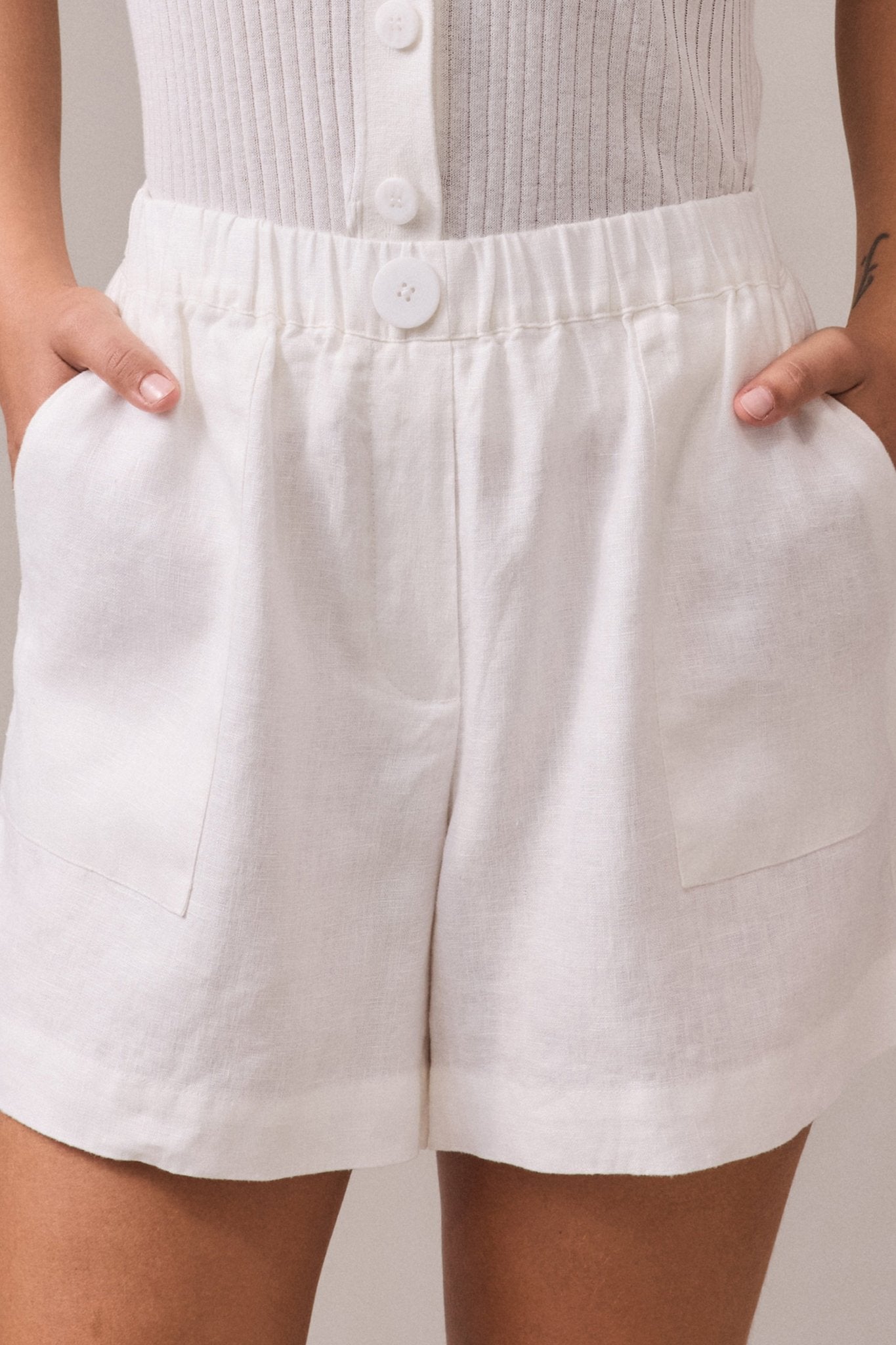 Detailed close-up of the waistband and pockets, emphasizing the refined linen texture and functional design.