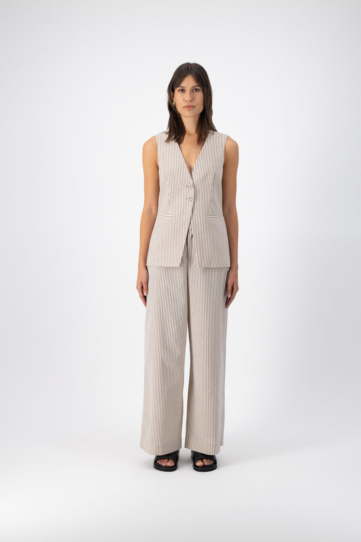 A woman is wearing a Hayes Linen Stripe Vest paired with wide-leg pants in the same color.