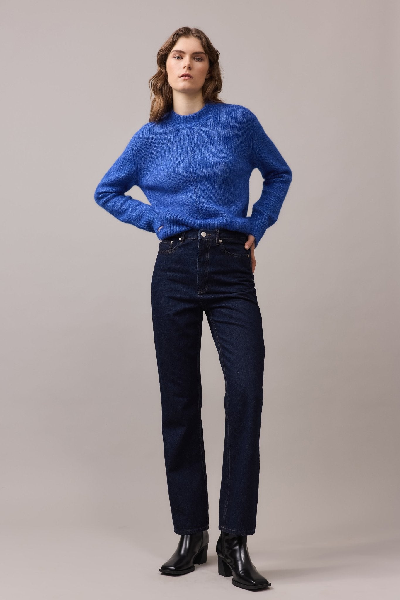 Woman wearing the Alfie Alpaca Cotton Lofty Knit in cobalt blue, styled with dark denim jeans and black boots for an effortless everyday look.