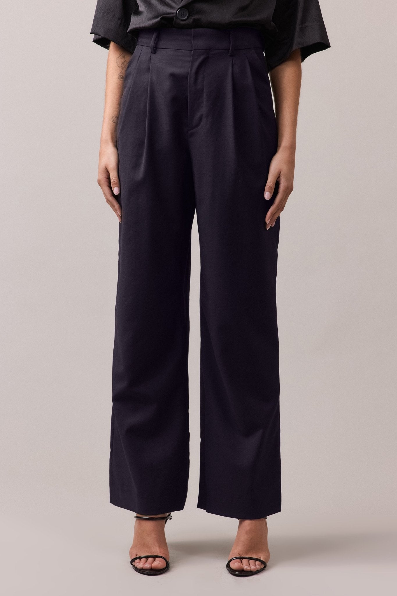 Woman wearing the Frankie Wide Leg Pant in 100% wool, showing the front of the pants. The high to mid waist, wide-leg fit, and double front pleat are visible, with side seam pockets