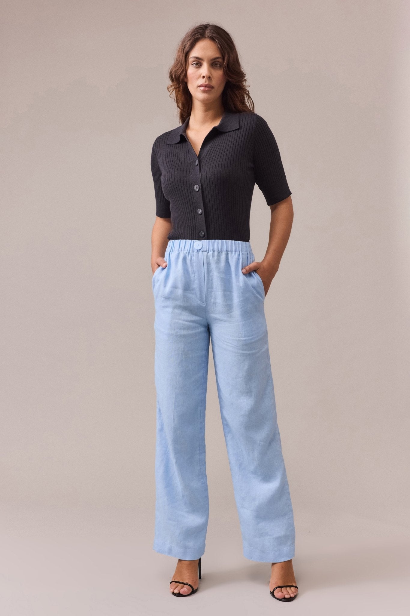 woman is wearing pale blue linen pants with black shirt