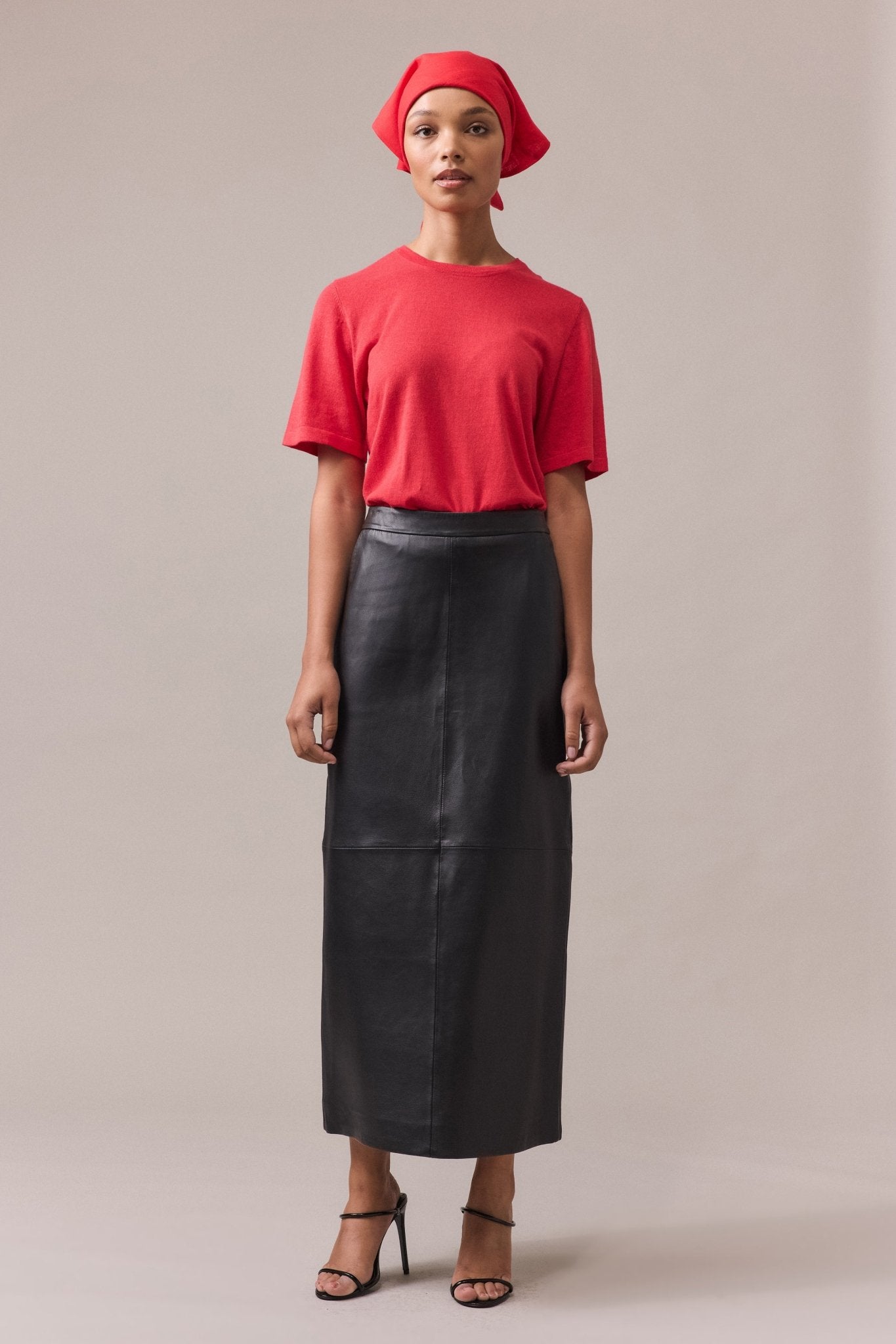 Woman wearing Kara leather pencil skirt paired with red tee.