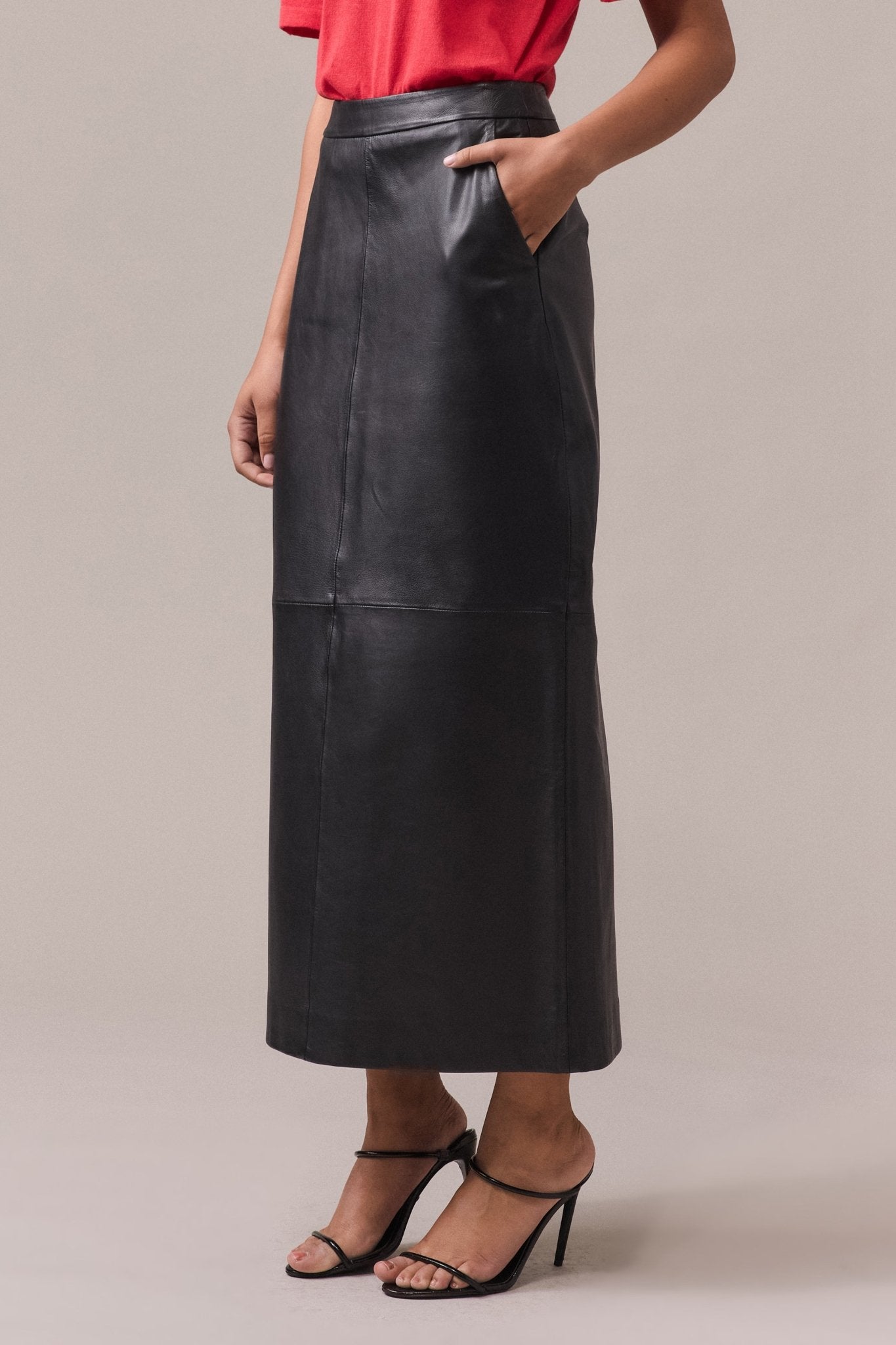 Woman's wearing Kara leather pencil skirt with hand in the pocket.