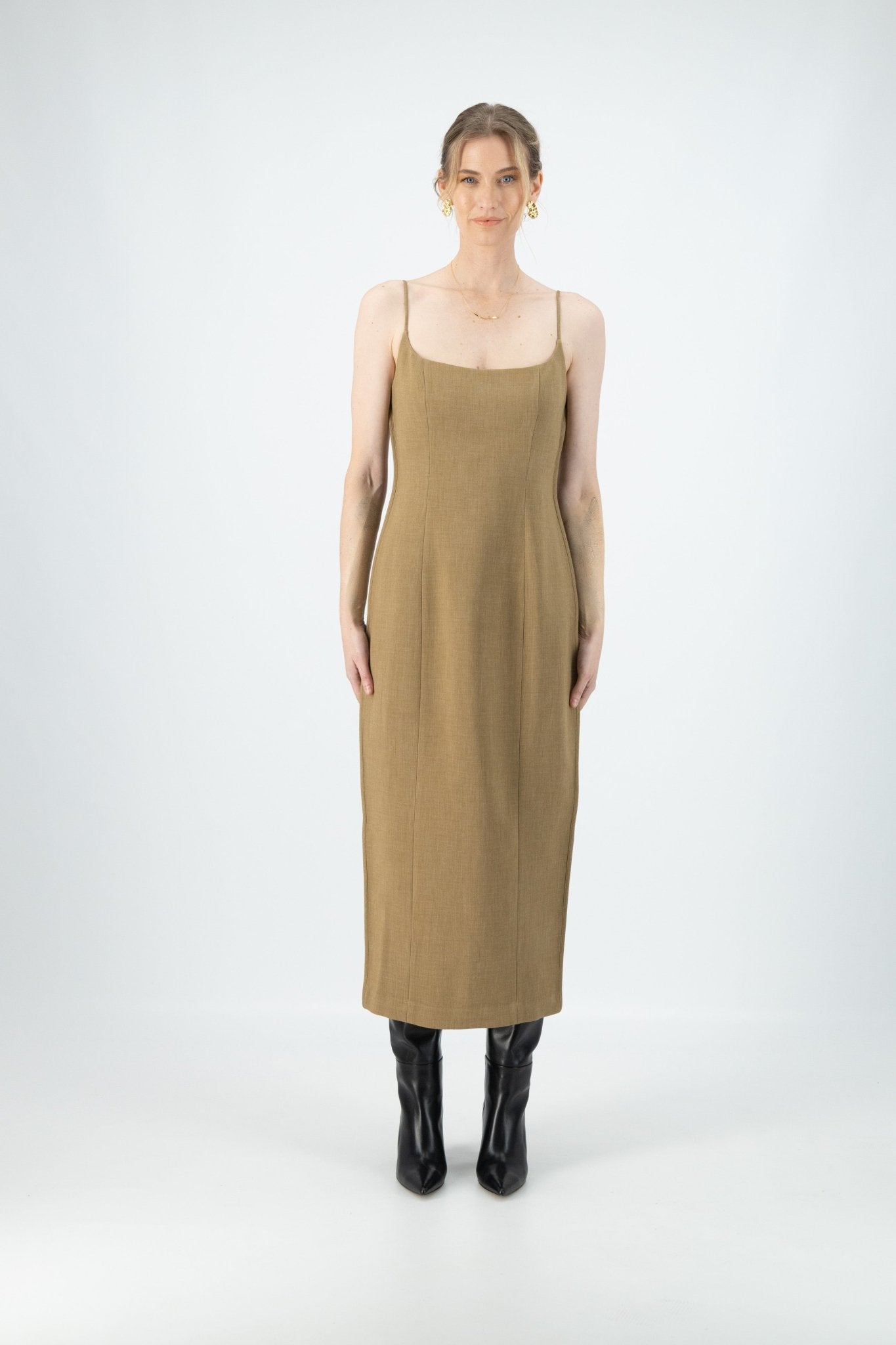 A woman is wearing Kiana Chantelle Dress. The dress is brown and midi, with thin straps.