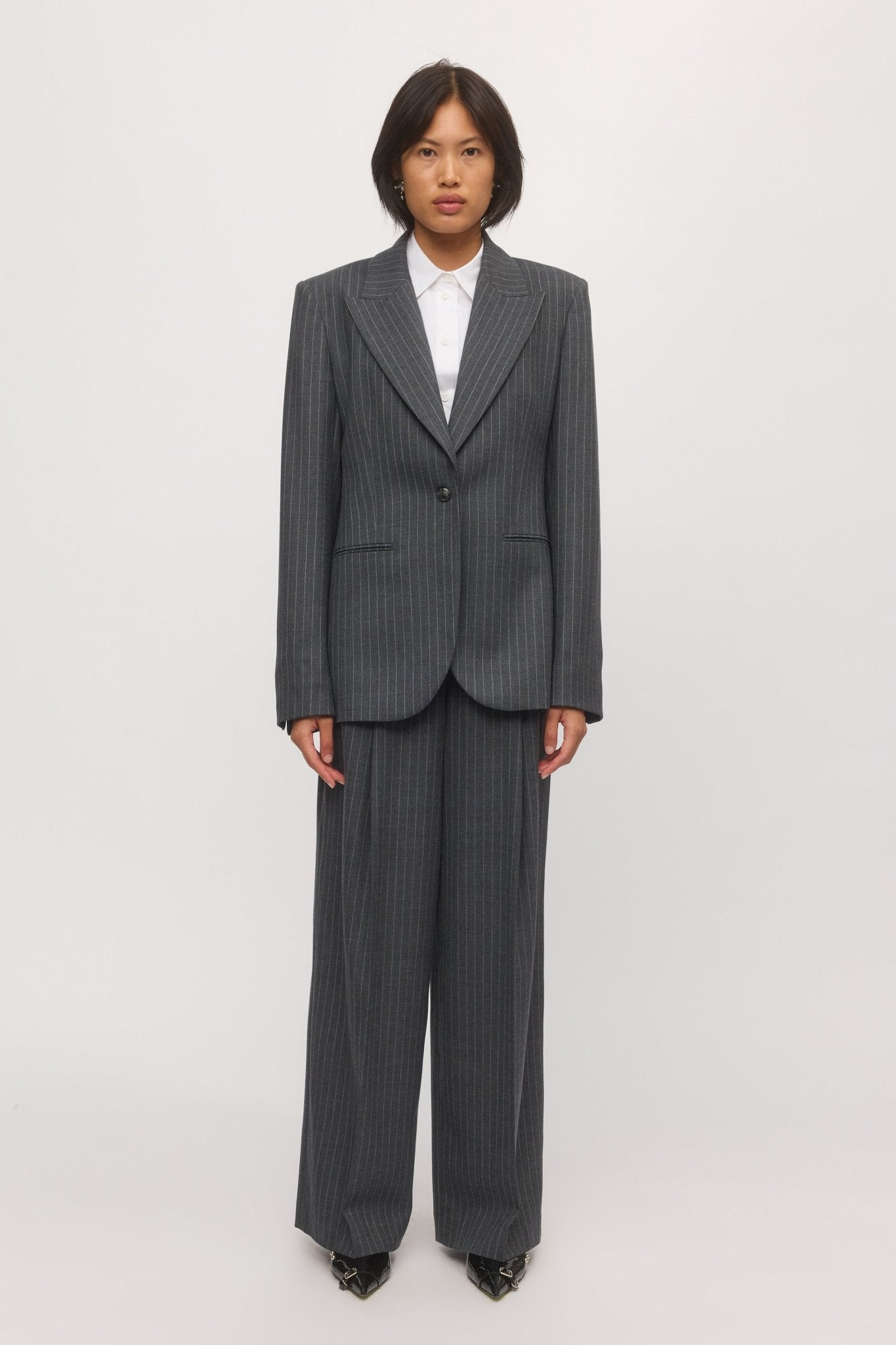 Woman wearing the Lola Wide Leg Pant in graphite stripe with the matching tailored blazer and white shirt. - Skin and Threads