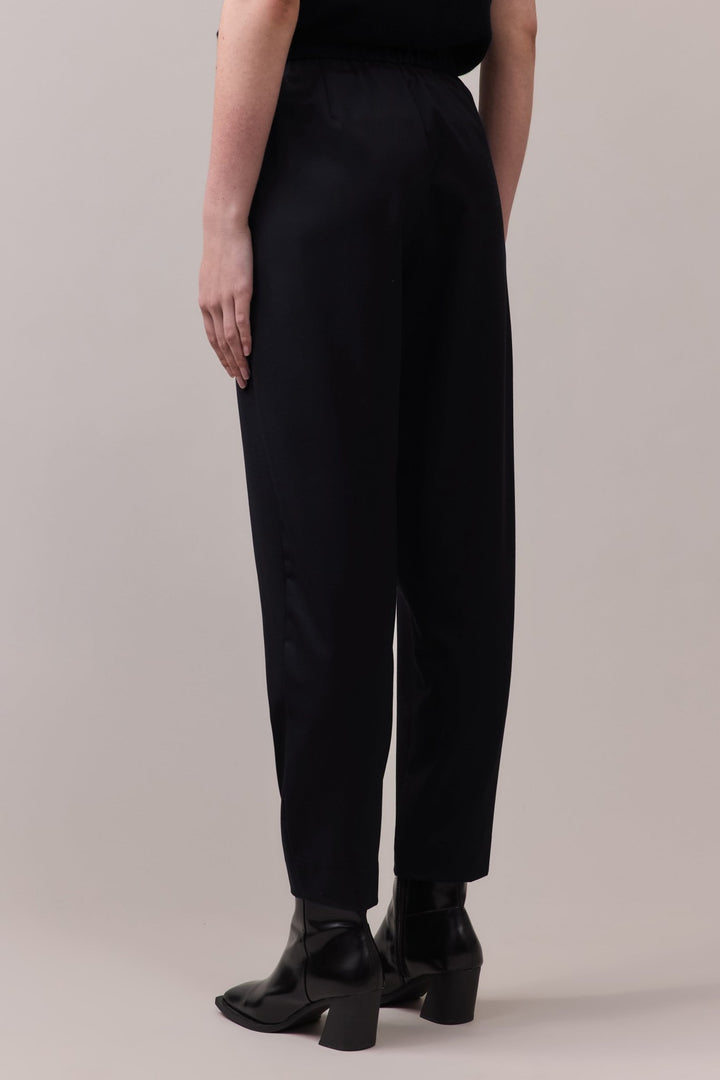 Back view of the black Marlow Casual Pant, showcasing the comfortable elastic waistband and the fluid movement of the wool fabric.