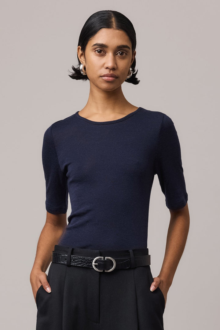 Close-up of a woman wearing an indigo Merino Wool Crew Neck Tee with elbow sleeves.