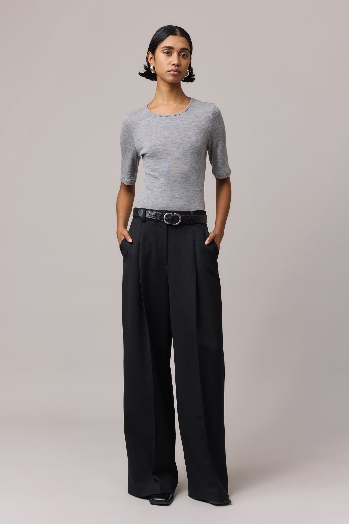 Woman wearing a grey Merino Wool Crew Neck Tee with elbow sleeves. The classic t-shirt fit is crafted from 100% fine Australian Merino wool.