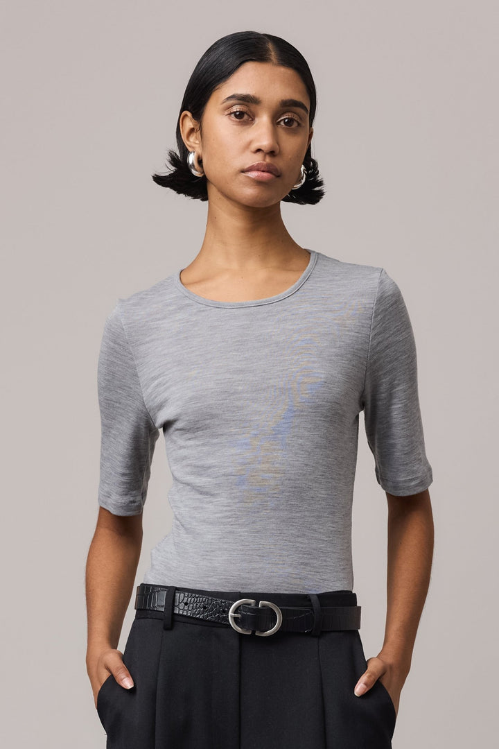 Close-up of a woman wearing a grey Merino Wool Crew Neck Tee with elbow sleeve.