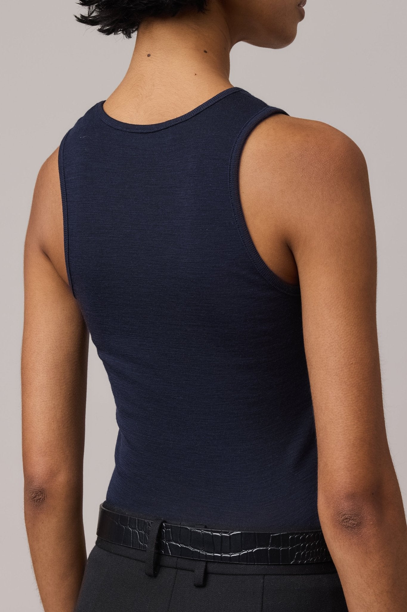 The back of an indigo Merino Wool Tank Top with a fitted crew neckline.