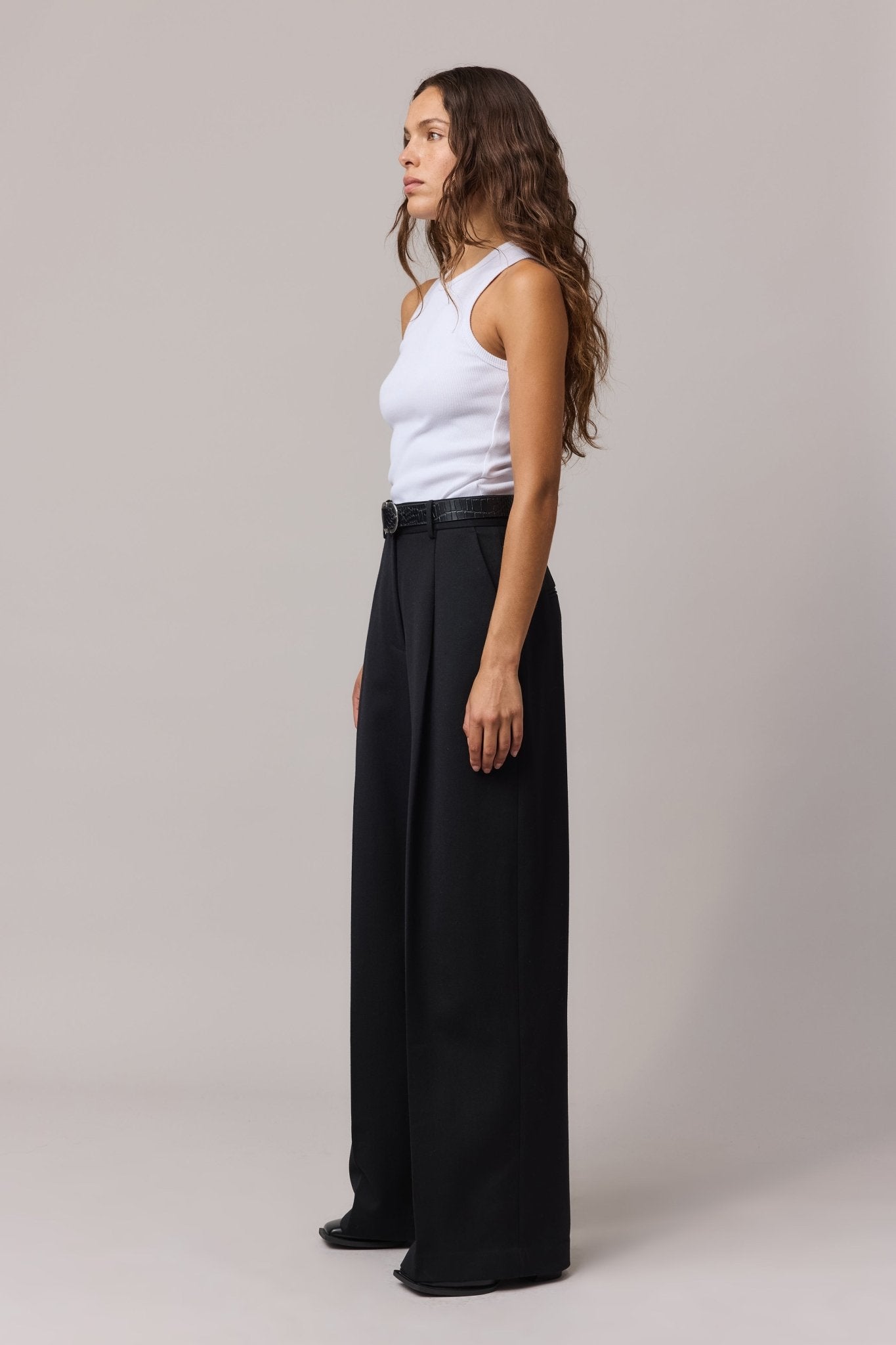 Side view of the woman in the white cotton top paired with wide leg pant.