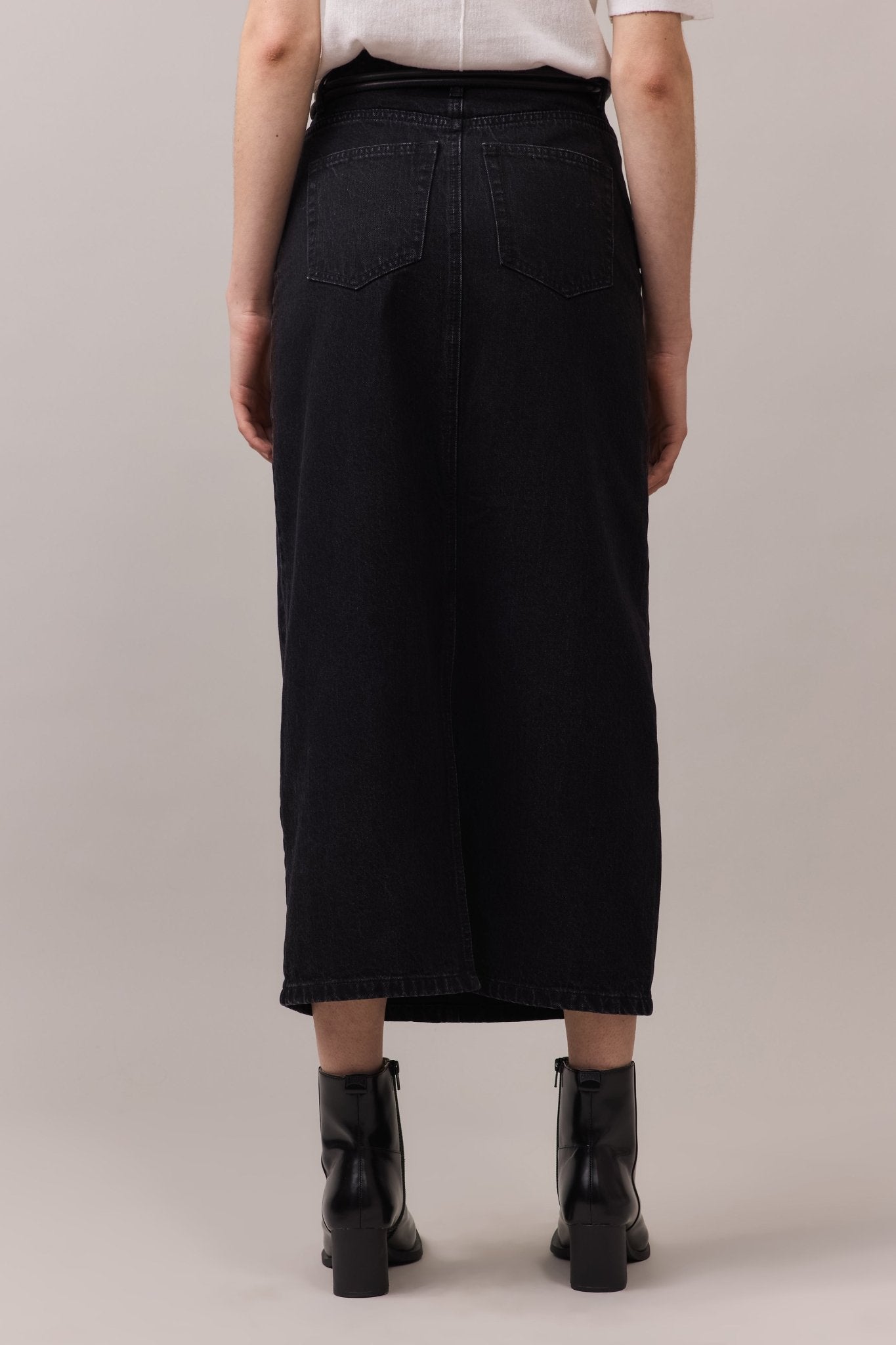 Back angle of the maxi denim skirt, focusing on its fit and the flattering shape it creates with the fitted waist and flowy skirt.